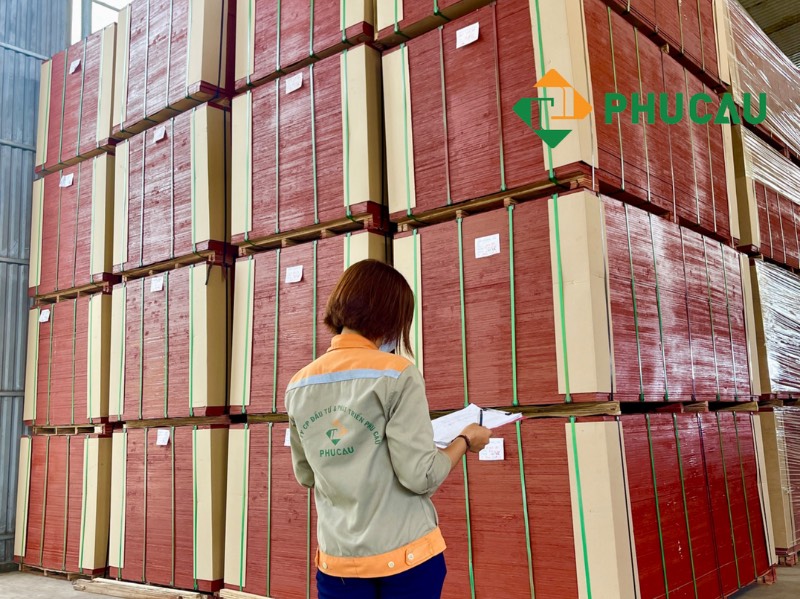 women workers wear Phu Cau shirt are checking the plywood stacks